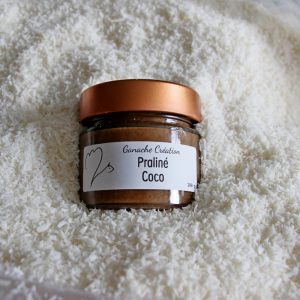 pot de praliné coco dans un tas de coco en poudre